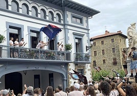 Udaletxeko balkoitik lortutako bandera astindu zuten irabazleek.