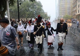 Algunas personas se resguardan de la lluvia mientras disfrutan de las actividades del 31 de agosto.