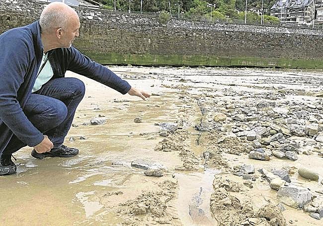 Jon Etxezarreta indica el borde del casco sumergido en la arena.