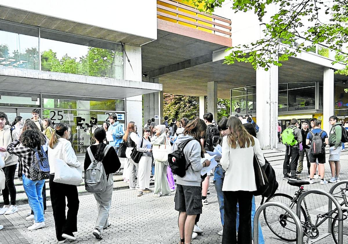 Alumnos aguardan en la puerta de la UPV, en Donostia.