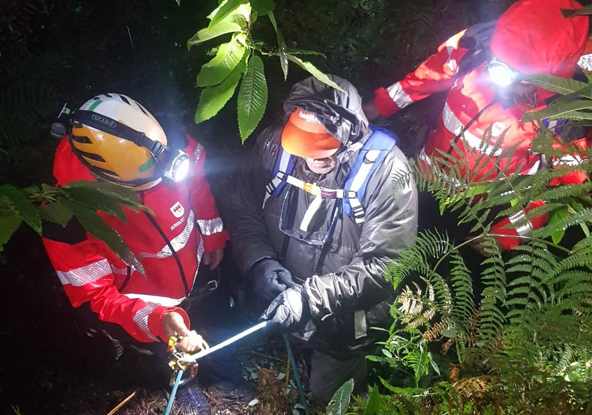 Los bomberos junto al excursionista durante el rescate.