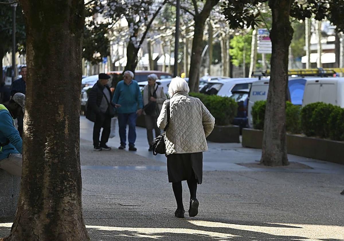 Una mujer mayor camina por la calle en Tolosa.