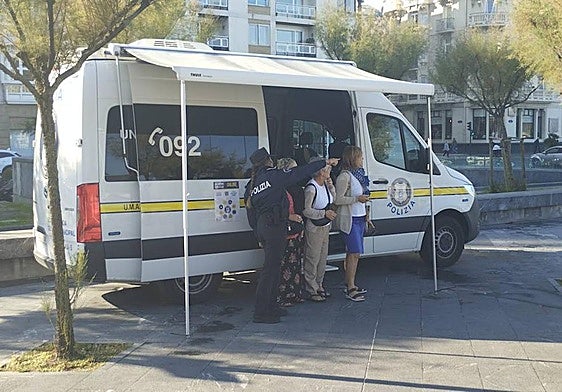 Una agente de la Guardia Municipal atiende a tres mujeres en la plaza Cervantes.