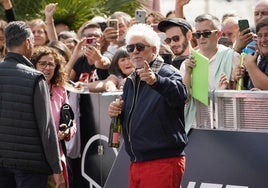 Pedro Almodóvar, con una botella de vino que le han regalado a su llegada a Donostia.