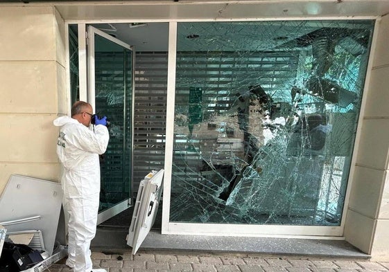 Un agente de la Guardia Civil inspecciona la sucursal bancaria.