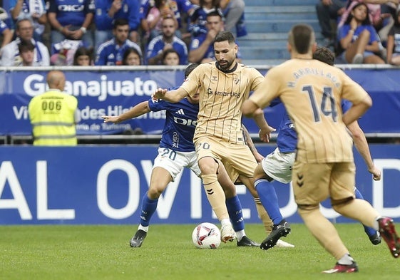 Antonio Puertas protege el balón ante dos jugadores del Real Oviedo.