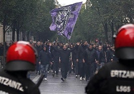 Dos Ertzainas, frente a un grupo de ultras del Anderlecht el pasado jueves en San Sebastián horas antes del encuentro frente a la Real Sociedad.