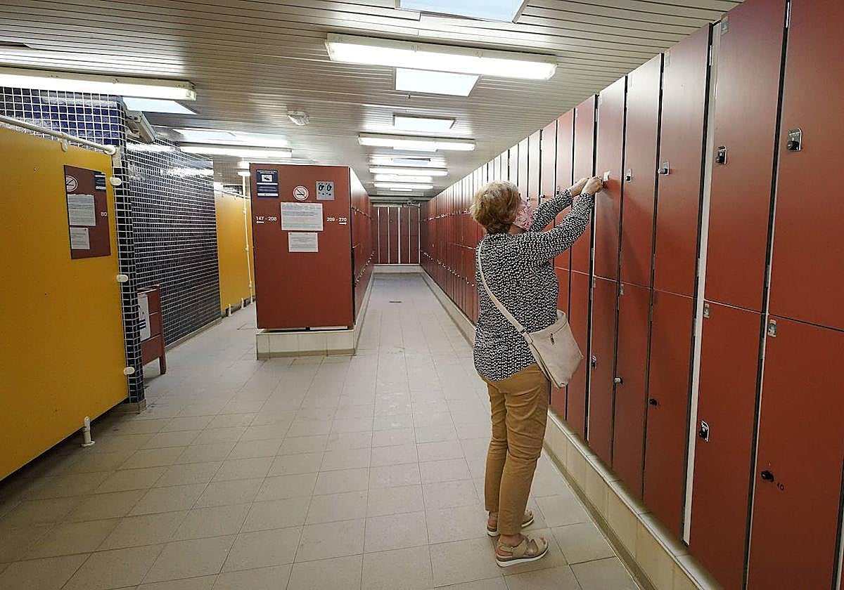 Una mujer abre una taquilla en la playa de La Concha, servicio que ha recibido este verano quejas por parte de los bañistas.