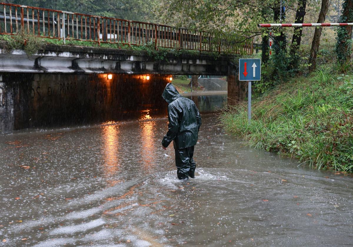 Un hombre ataviado con un traje de agua cruza una enorme balsa de agua en Jaizubia, entre Irun y Hondarribia