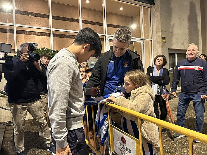 Take Cubo firma un autógrafo a Laura, una joven realista, acompañada por su padre Narcís, en el hotel donde se hospeda la Real en Girona.