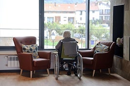 Una mujer en silla de ruedas observa desde la ventana de una residencia en Usurbil.