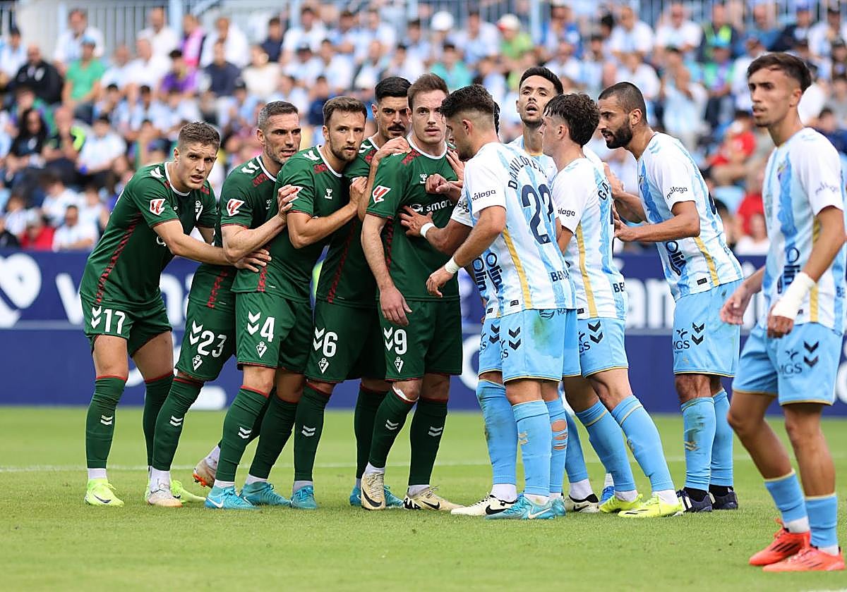 Los jugadores del Eibar forman el clásico 'trenecito' para rematar un córner, ayer en La Rosaleda.