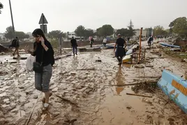 Vecinos caminan entre el lodo acumulado por las intensas lluvias de la fuerte Dana, este miércoles en Picaña, Valencia.