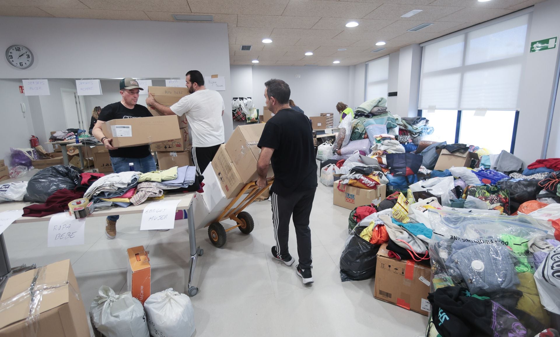 Voluntarios organizan el material entregado por decenas de personas en el punto de recogida de Irun.