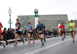 Los corredores de la behobia a su paso por el puente Kursaal bajo el cielo cubierto.