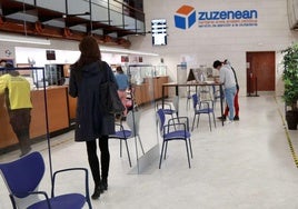 Varias personas esperan a ser atendidas en la oficina de Zuzenean, del Gobierno Vasco, situada en la calle Andia de Donostia.