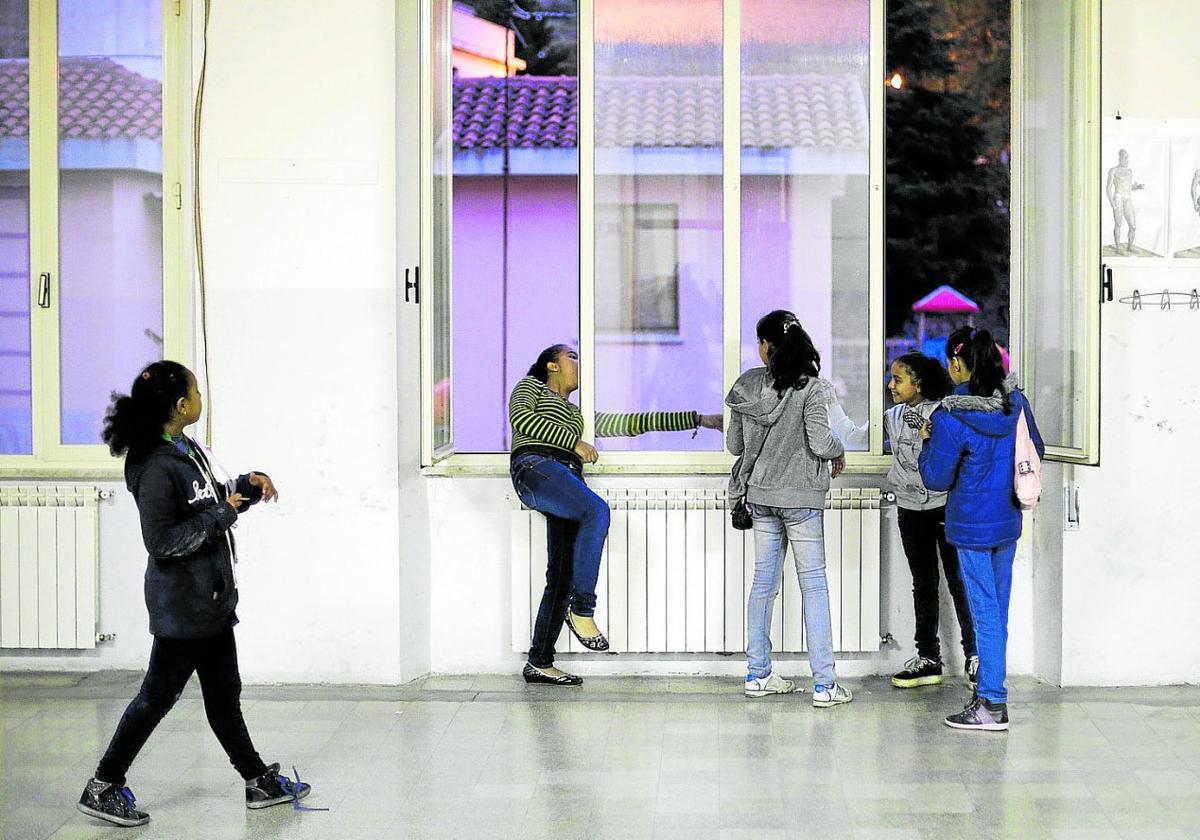 Varias niñas, en el pasillo de un colegio.