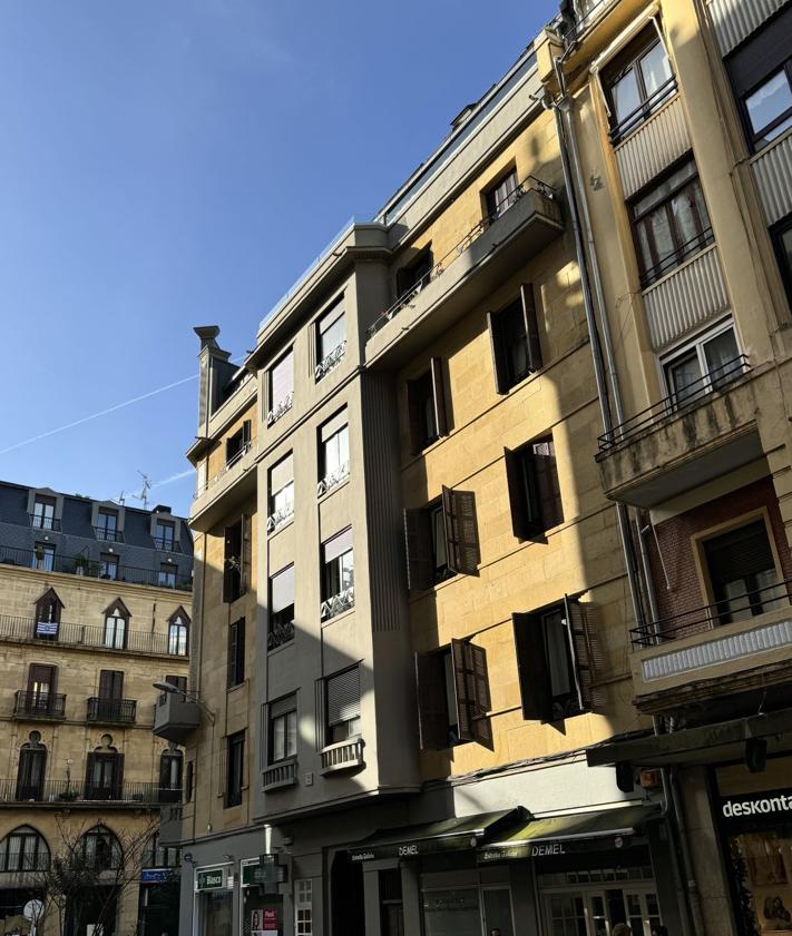 Imagen secundaria 2 - Detalle del pórtico decó en la fachada de esquina. Debajo, fachada lateral del edificio. 