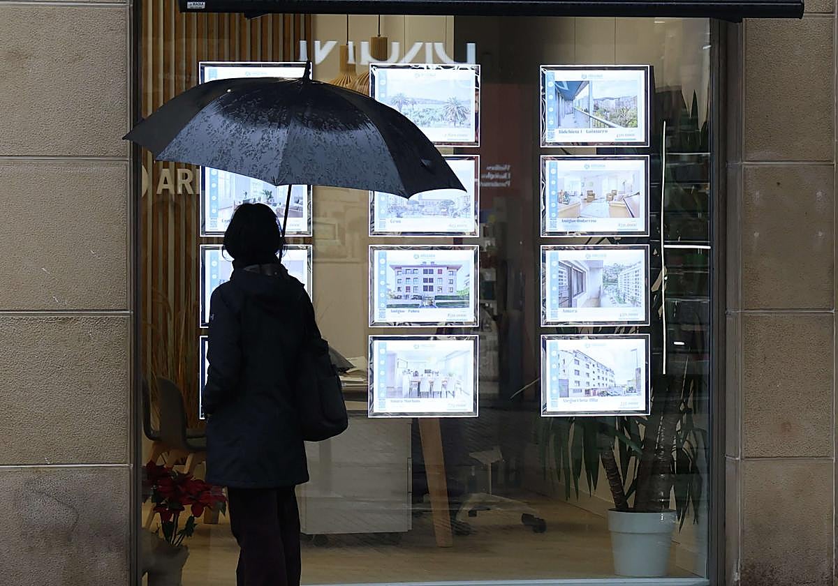 Una mujer observa la oferta en una agencia inmobiliaria.