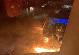 Vista de los contenedores calcinados y el coche dañado.