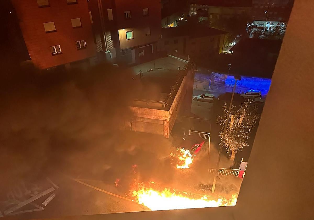 Vista de los contenedores calcinados y el coche dañado.