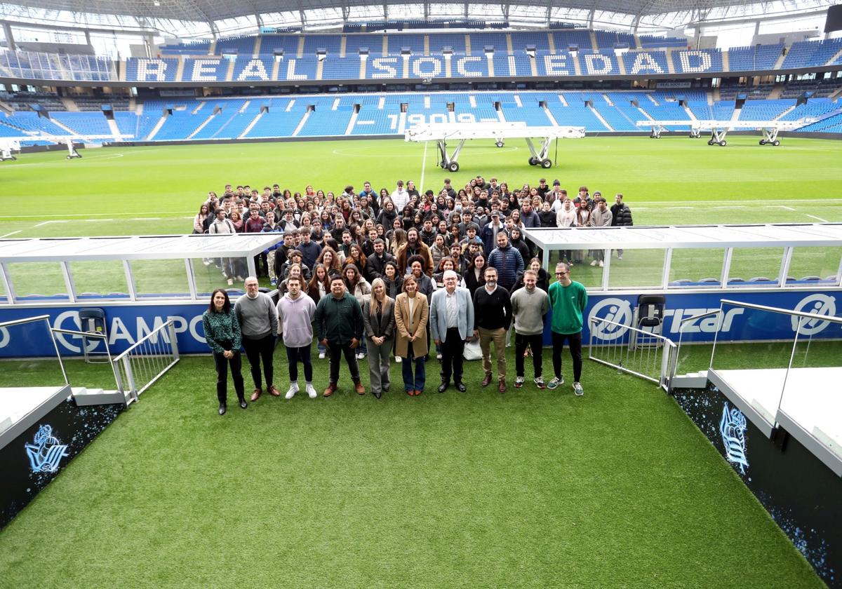 Los jóvenes asistentes al evento Ekinn San Sebastián posan junto a los emprendedores, los organizadores y las autoridades sobre el césped del Reale Arena.