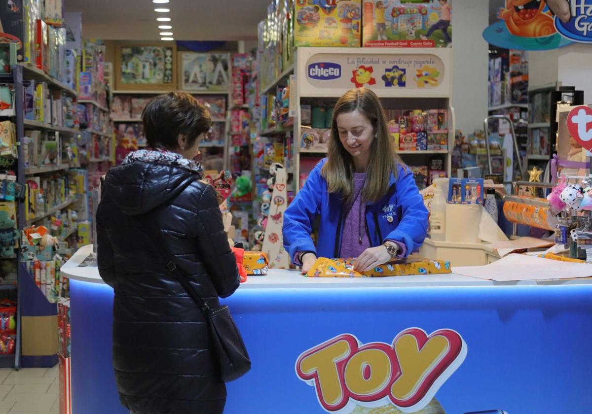 Una trabajadora envuelve un regalo en una juguetería donostiarra.