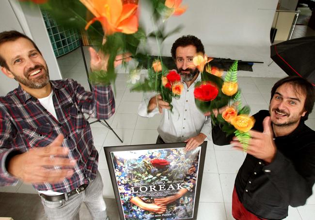 Jose Mari Goenaga, Jon Garaño y Aitor Arregi, con el cartel de 'Loreak'.