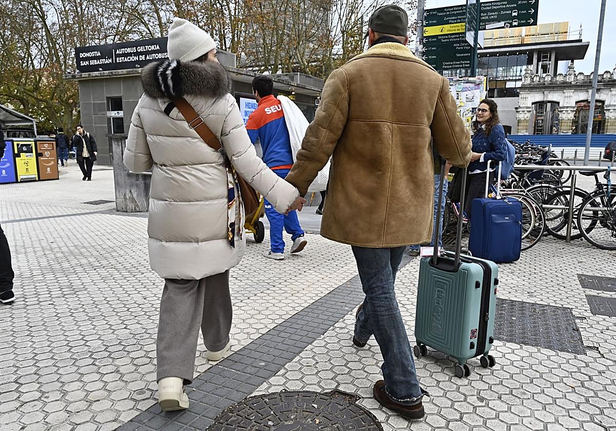 Dos turistas con maletas salen de la estación de autobuses de Donostia para pasar este puente de diciembre.