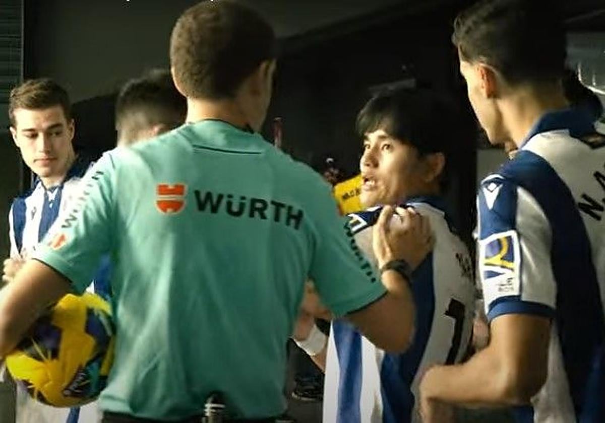 El árbitro Melero López pone la mano en el hombro de Take Kubo durante su charla previa al segundo tiempo