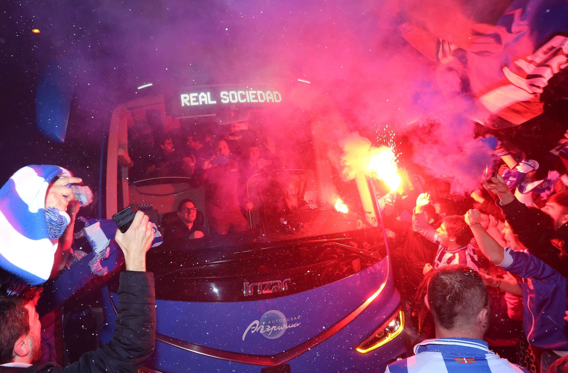 Aficionados de la Real reciben al autobús del equipo.