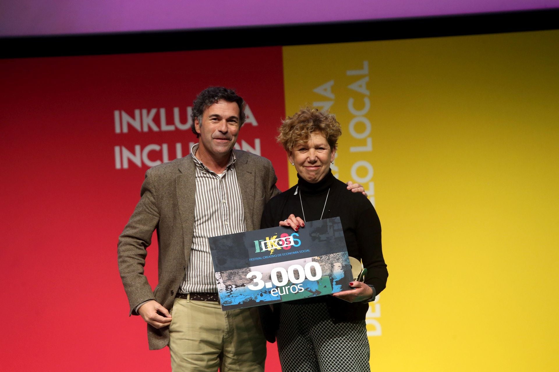 Isabel Apaolaza, en representación de Ane Otaduy / Cada persona cuenta. Unai Andueza, director general de Promoción Económica de la Diputación Foral de Gipuzkoa, entrega el EKOS de Oro en la categoría Público General Gráfico a Isabel.