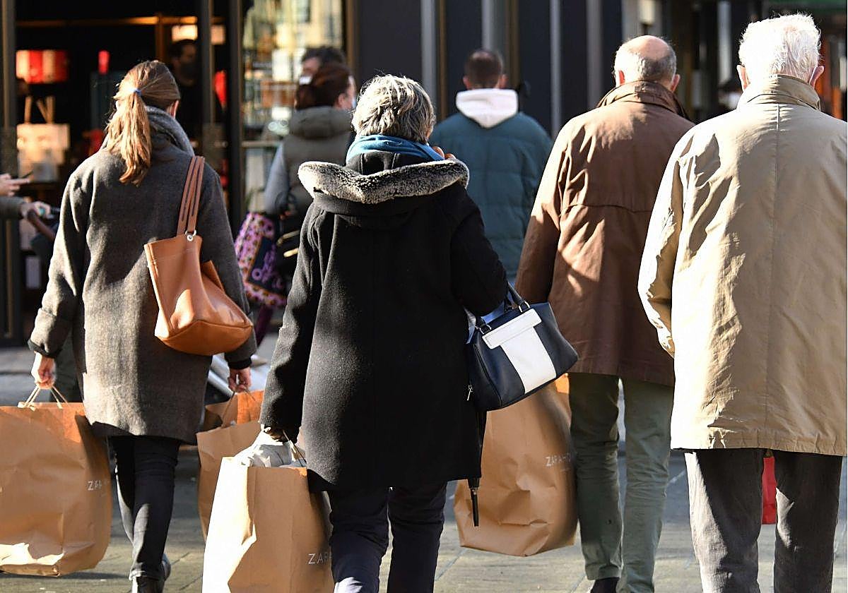 Varias personas realizan compras navideñas en Donostia.