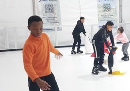 Varios jóvenes disfrutan en la pista de hielo.