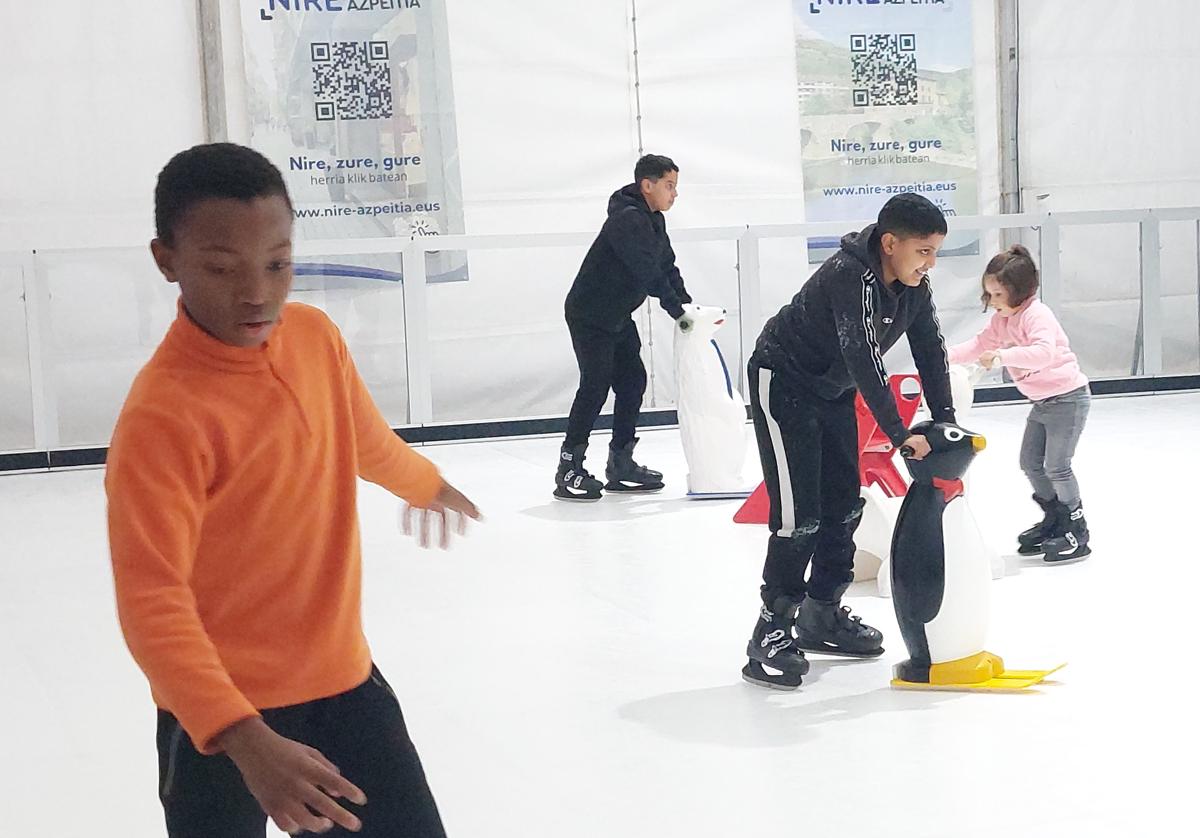 Varios jóvenes disfrutan en la pista de hielo.