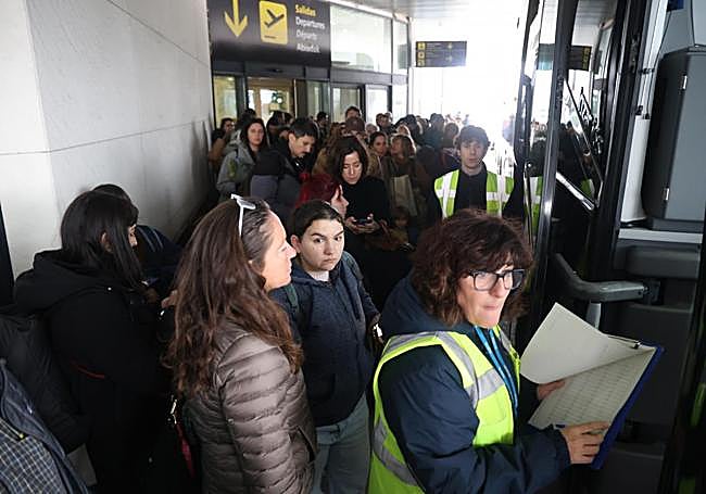 Colas de pasajeros para subirse al autobús para coger el avión en Loiu