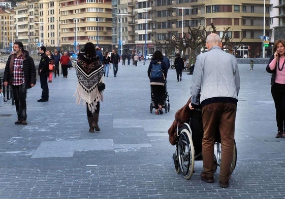 Un hombre empuja una silla de ruedas en San Sebastián.