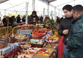 Dos hombres contemplan uno de los puestos en la feria de 2024.