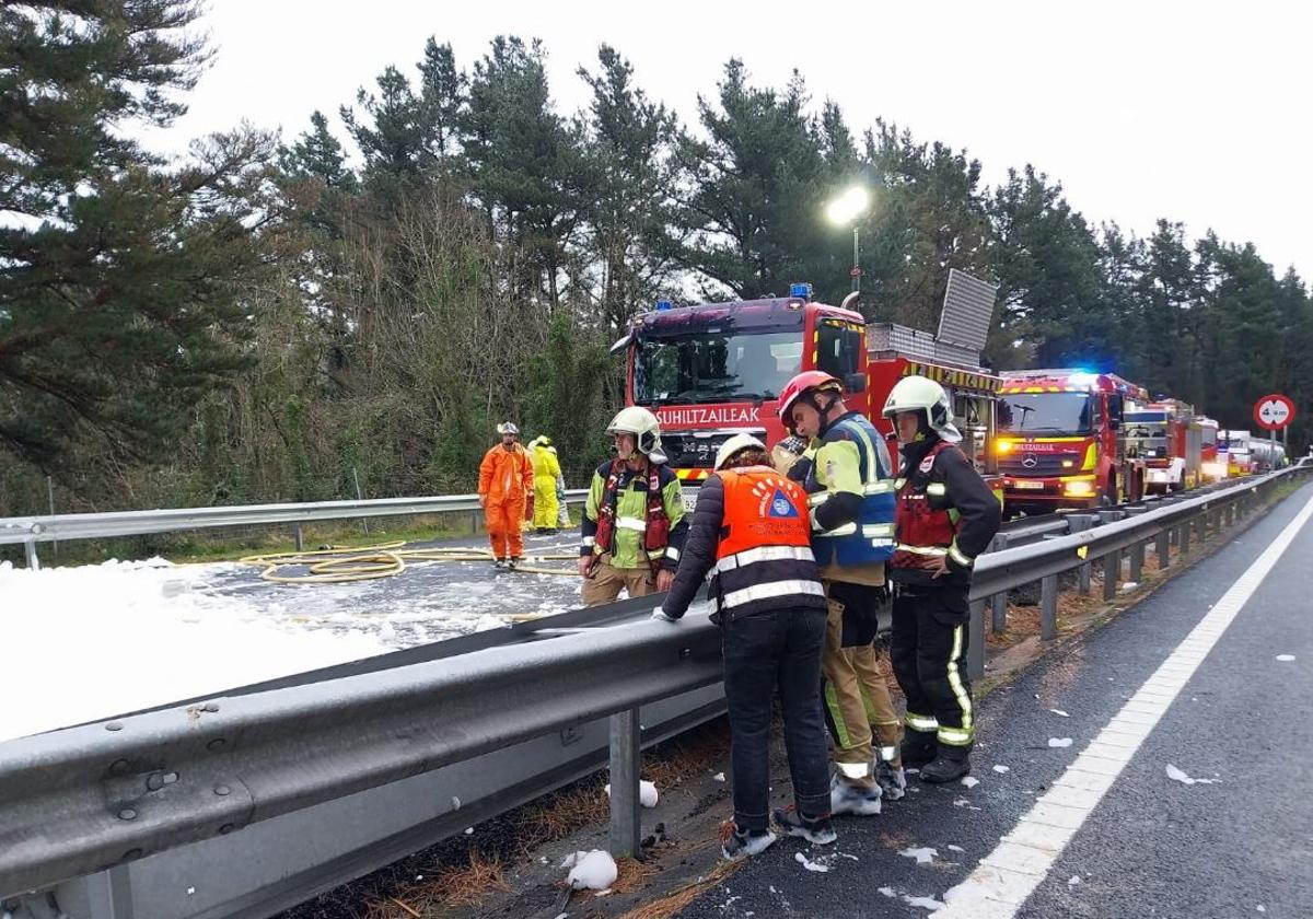 Operacin de limpieza de la calzada tras el vertido de queroseno desde el camin volcado.