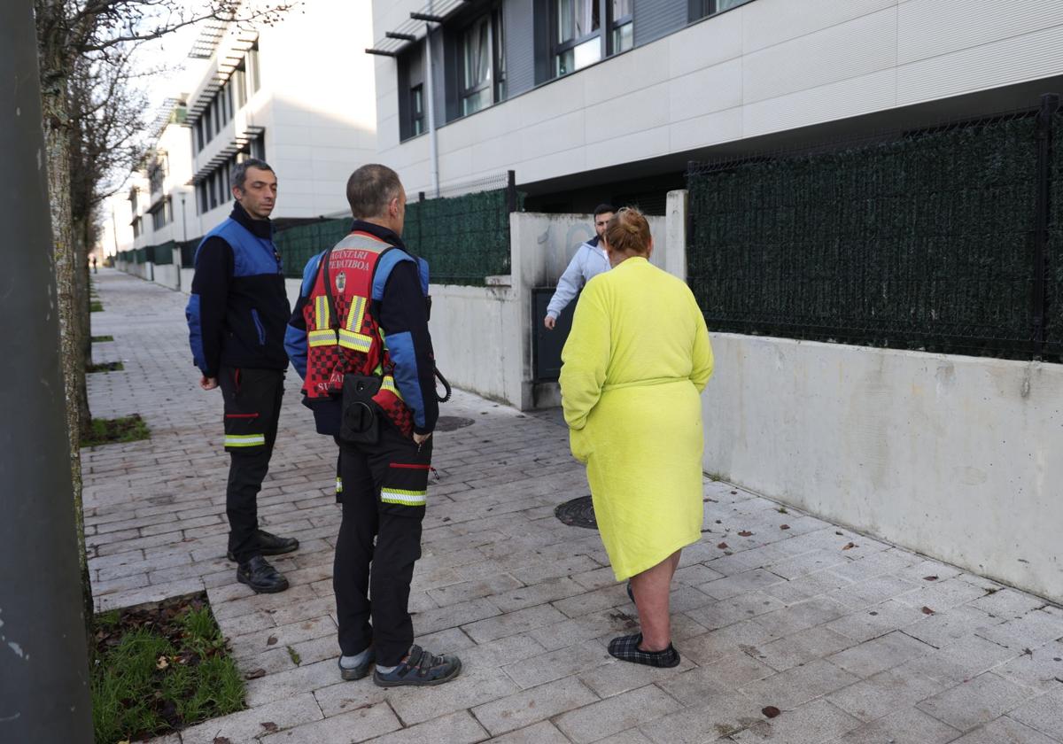 Bomberos atienden a residentes de uno de los portales afectados por el incendio.