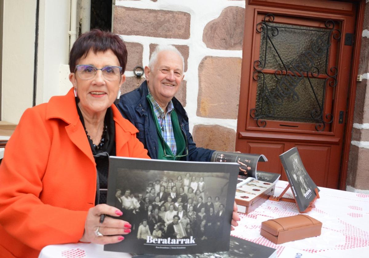 Rosa Mari, con el collar de su madre y Totono, los dos hermanos con su último libro con imágenes de sus vecinos, ante la puerta de su casa.