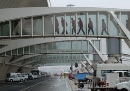 Varios pasajeros cruzan las pasarelas de embarque en el aeropuerto de Bilbao.