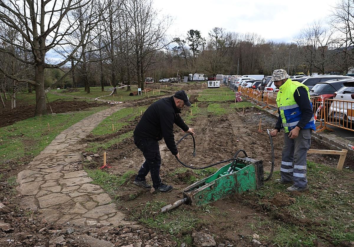 Dos operarios trabajan junto a uno de los aparcamientos donde se construirá el edificio modular.