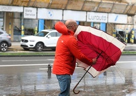 Un hombre que intenta refugiarse de la lluvia en el Kursaal