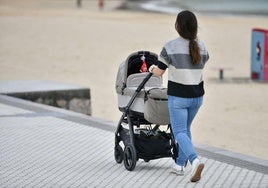 Una mujer pasea a su bebé por Donostia.