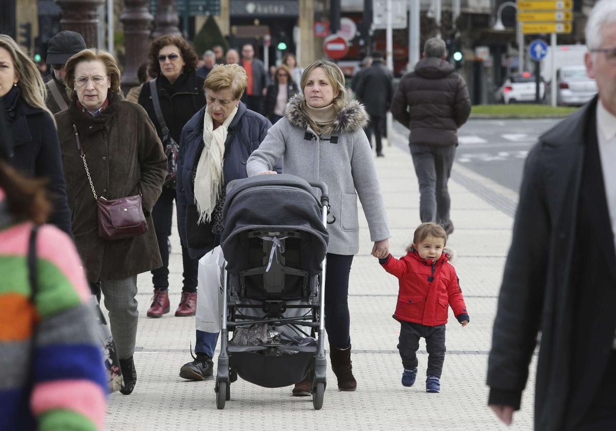 Una mujer, con un carro y un niño en San Sebastián.
