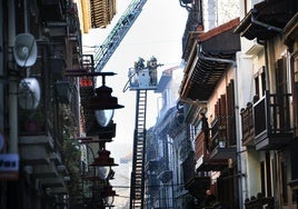Los bomberos sofocan el incendio en el bloque número 36 de Kale Nagusia de Hernani, en pleno casco histórico.