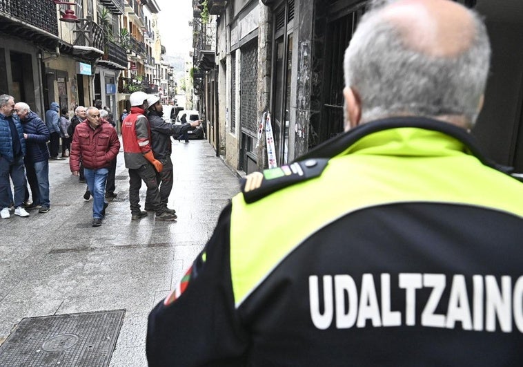 Municipal, bomberos y técnicos en el portal en el que se produjo el incendio.