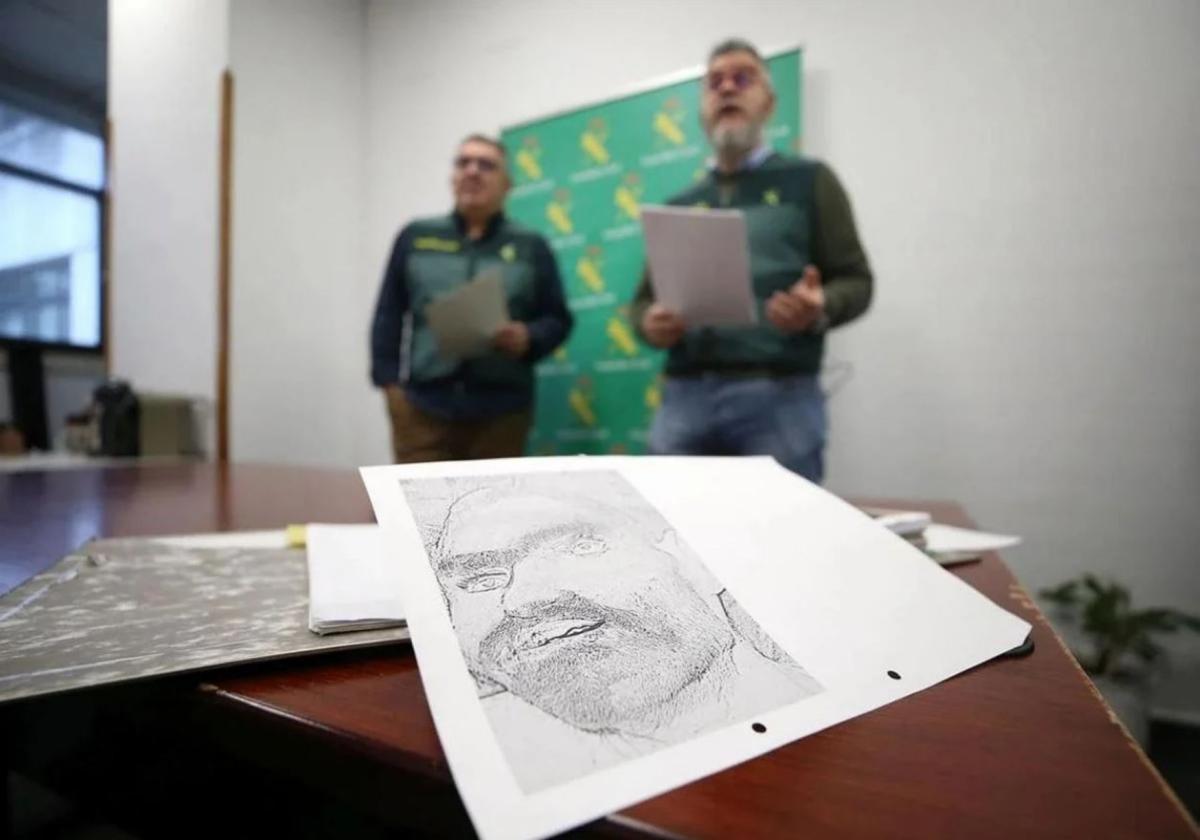 El cabo Javier y el sargento Miguel, de la Policía Judicial de la Guardia Civil de Asturias, junto a un retrado del 'hombre de Somiedo'.