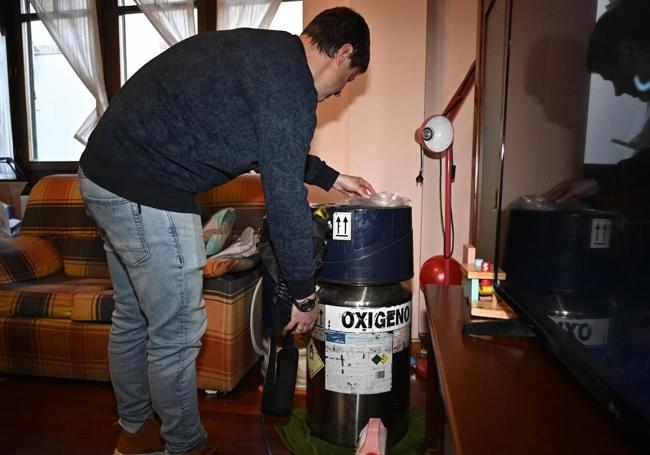 Thomas con la bombona de oxígeno que necesitan en casa para la respiración del pequeño